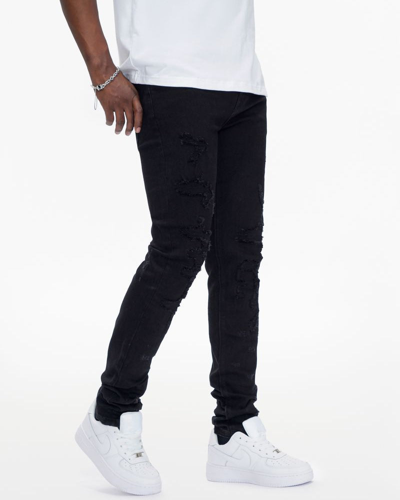 Person wearing black jeans and white sneakers on a white background