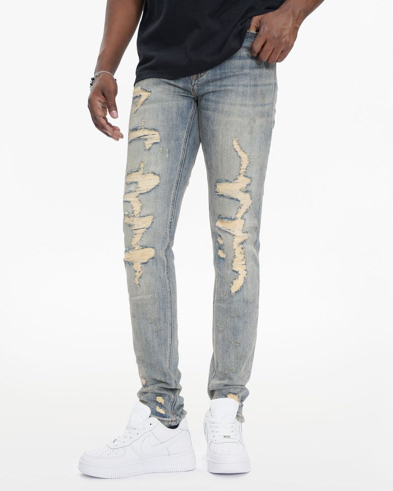 Person wearing light blue distressed jeans on a white background