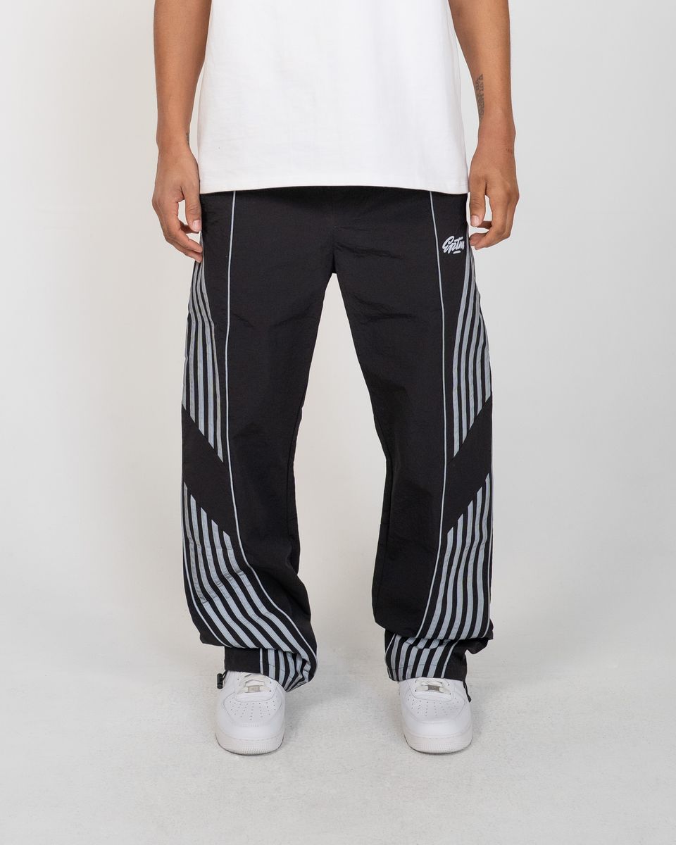 Person wearing black and white striped pants with a brand logo on a white background
