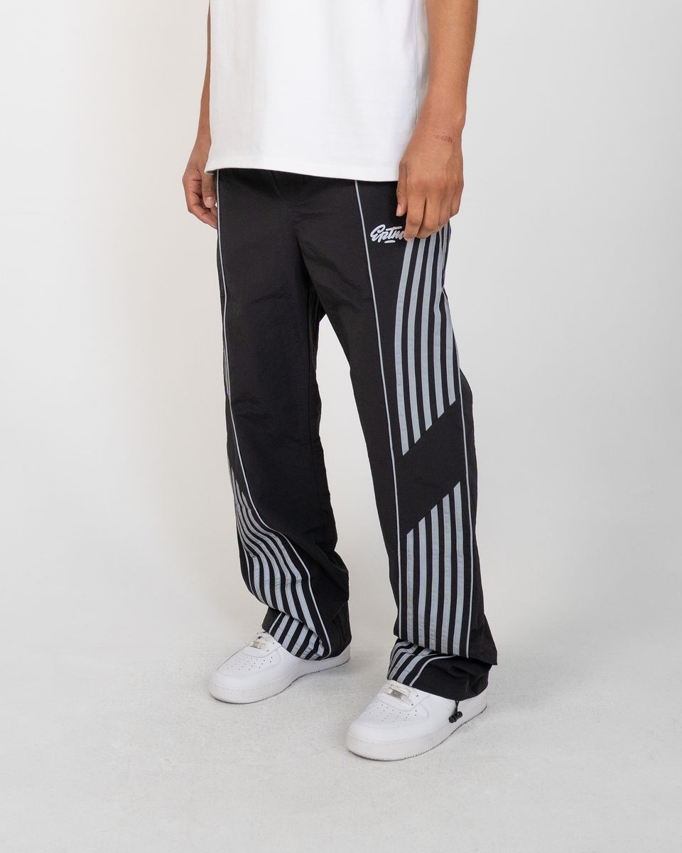 Person wearing black and white striped pants with a brand logo on a white background