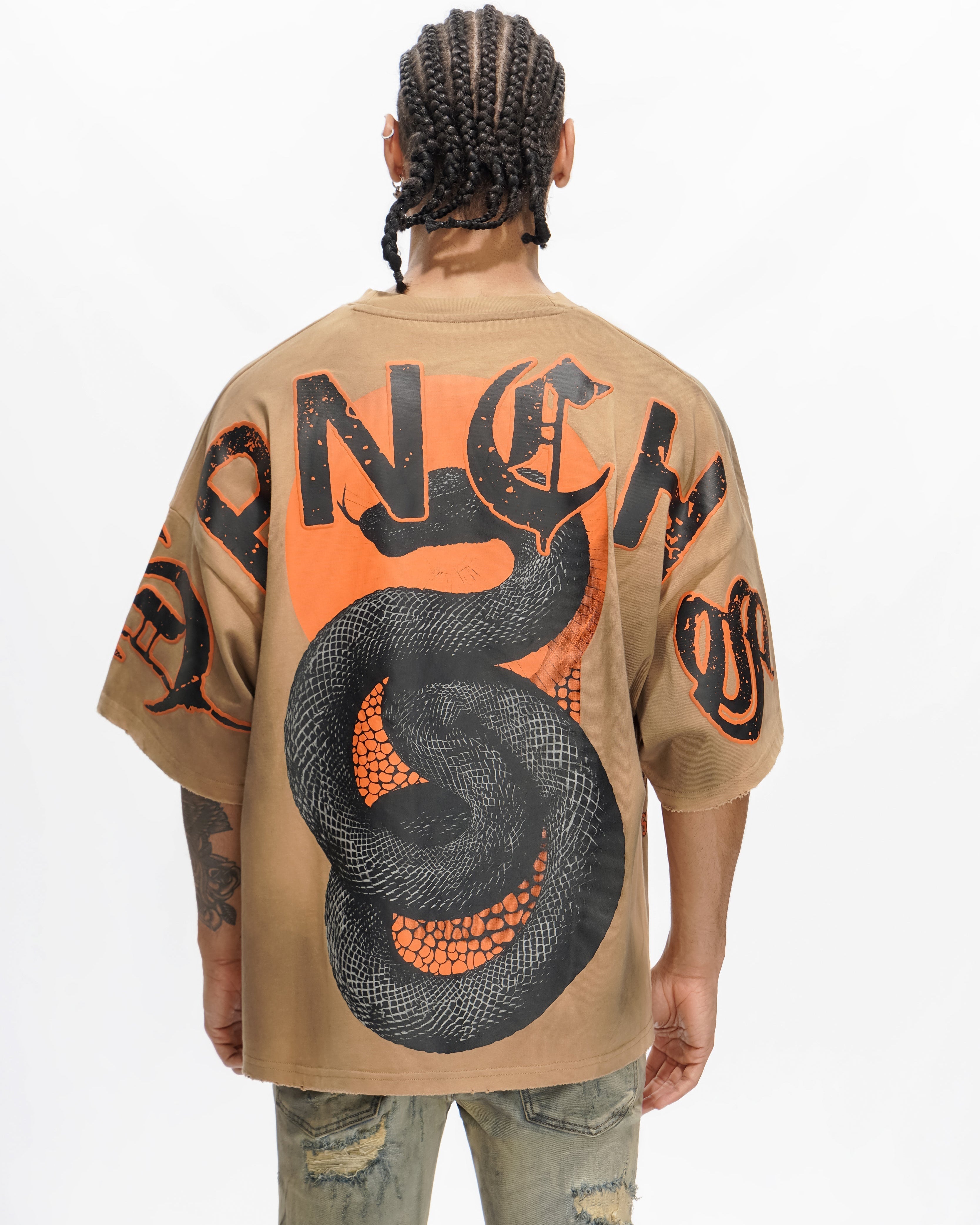 Person wearing a beige shirt with a large black and orange snake design on the back.