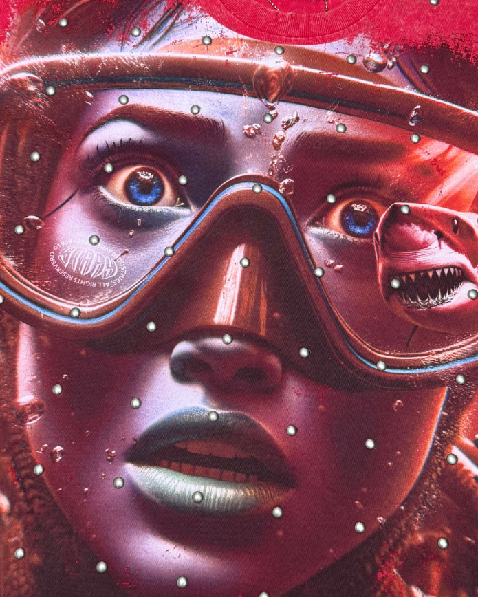 Close-up of a person wearing goggles with a red and metallic color scheme.
