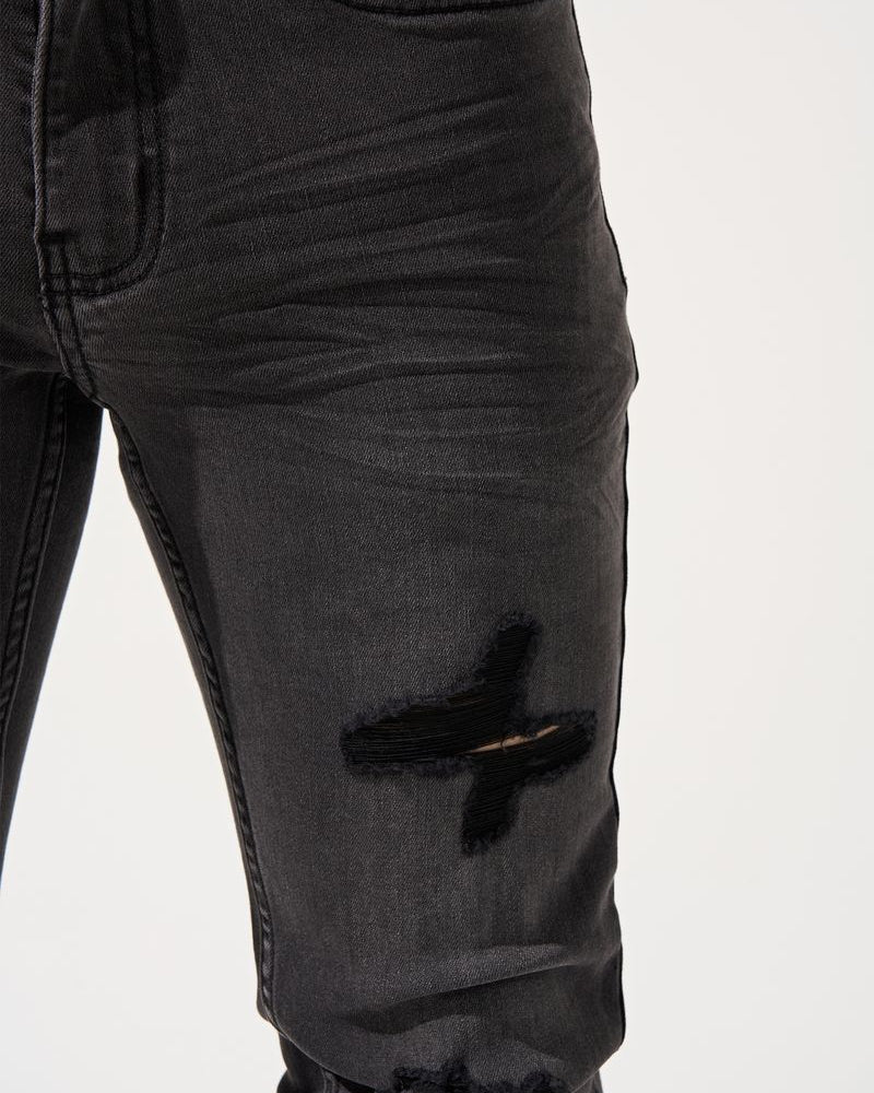 Black distressed jeans on a white background