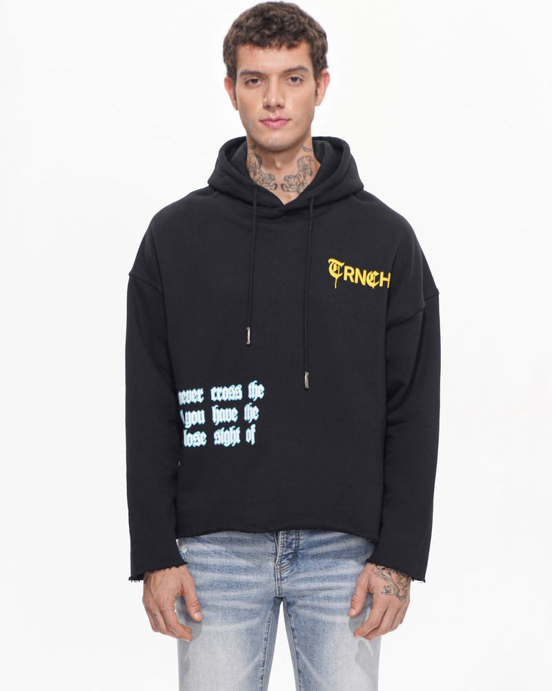 Person wearing a black hoodie with yellow text on a white background