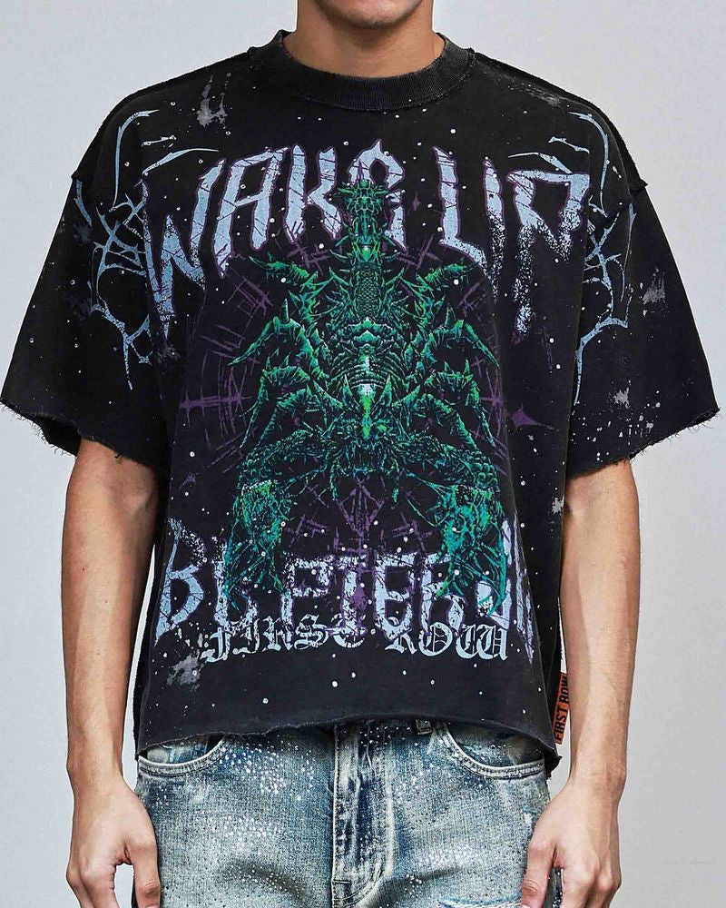 Person wearing a black graphic t-shirt with a green alien design and text.