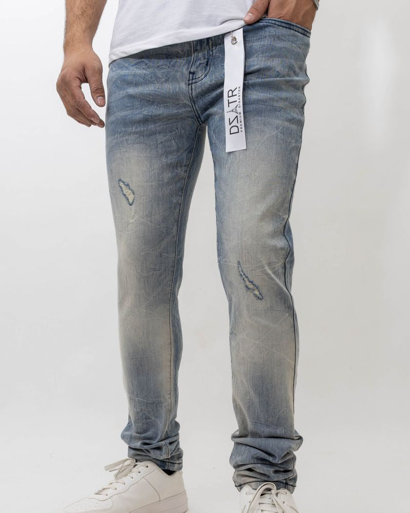 Person wearing light blue distressed jeans with a visible brand tag on a white background