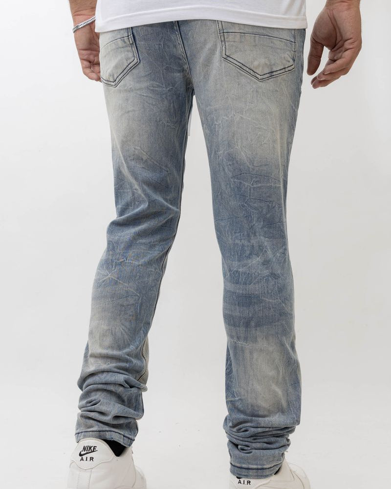 Person wearing light blue jeans and white sneakers on a white background