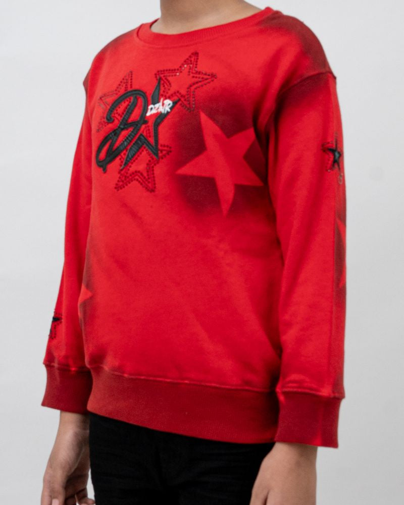 Red sweatshirt with star design worn by a person on a white background
