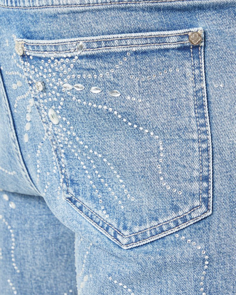 Close-up of a blue denim pocket with decorative stitching.