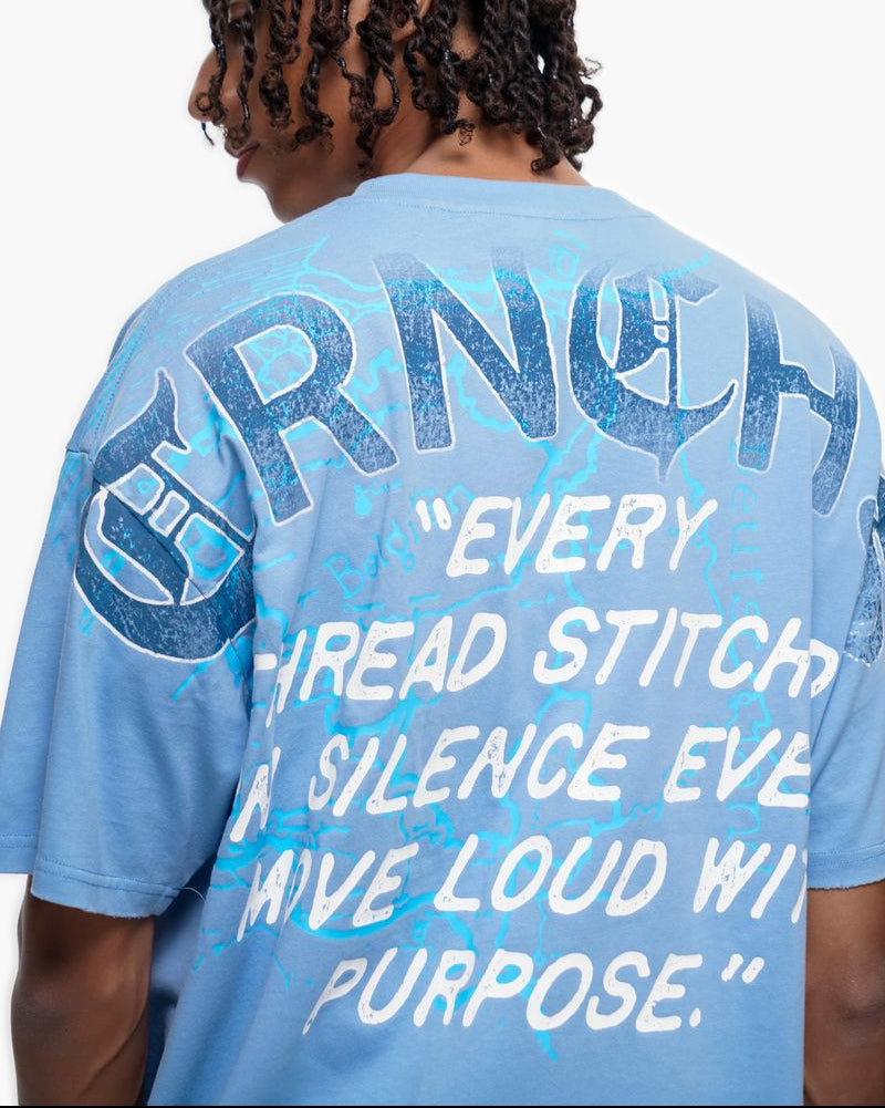 Person wearing a blue t-shirt with text and graphics on the back