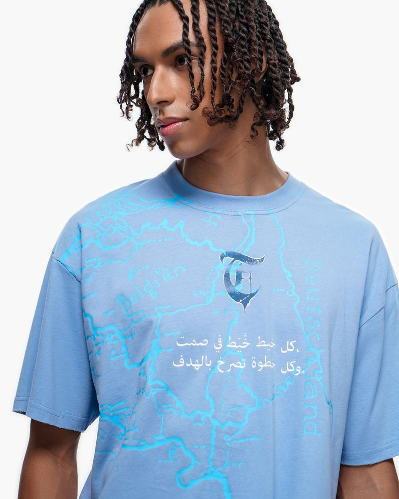Person wearing a blue t-shirt with Arabic text and graphics on a white background