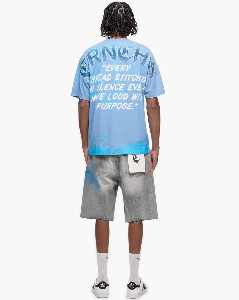 Person wearing a blue t-shirt with text and gray shorts on a white background