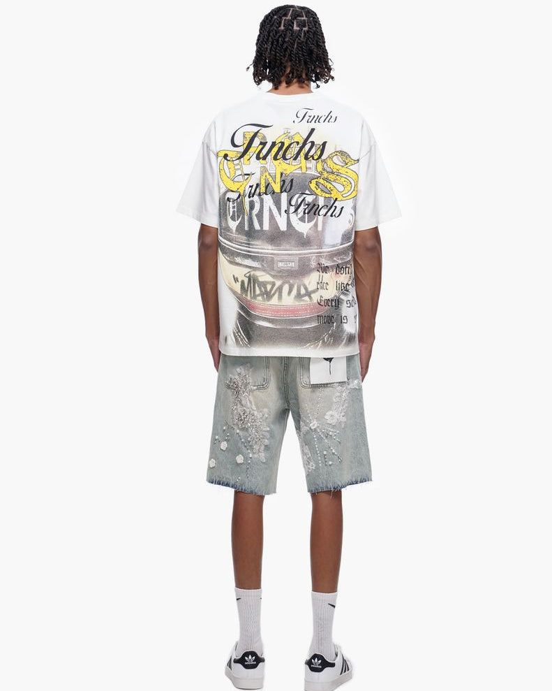 Person wearing a white graphic t-shirt and light gray shorts on a white background