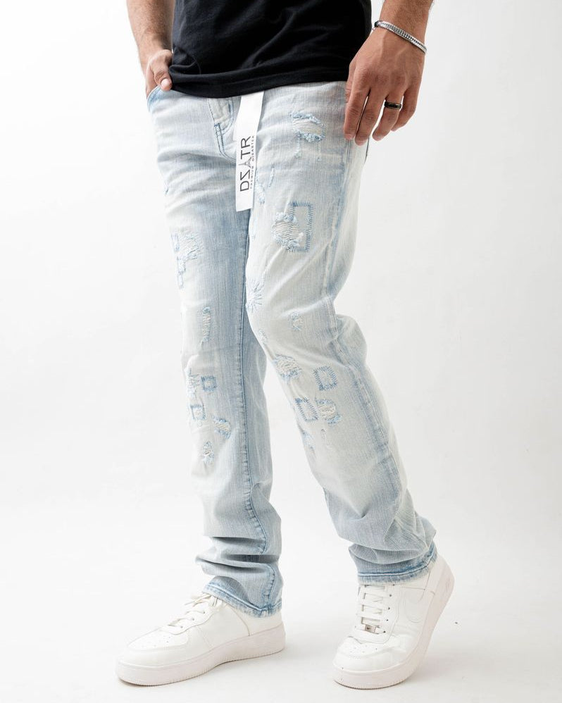 Person wearing light blue jeans with brand label on a white background