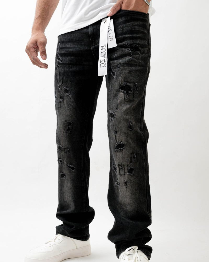 Person wearing black distressed jeans with a white background