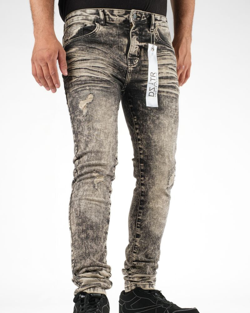 Person wearing distressed gray jeans with a visible brand tag on a white background
