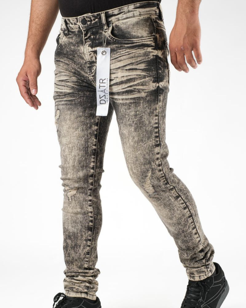 Person wearing distressed gray jeans with a visible brand tag on a white background