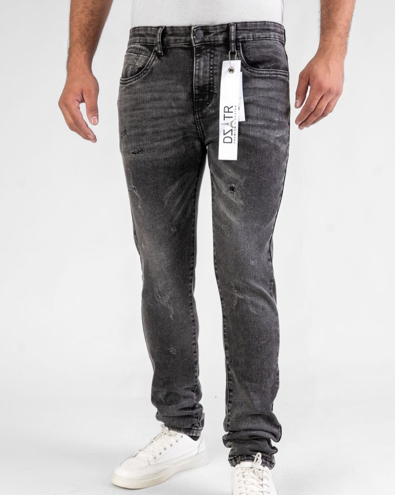 Person wearing gray jeans with a brand tag on a white background