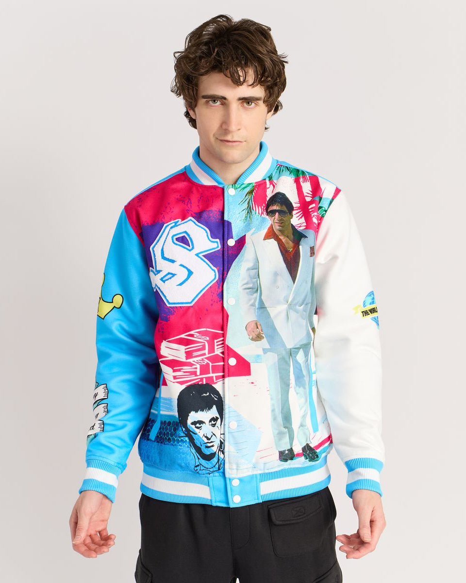 Person wearing a colorful jacket with graphic designs on a plain background