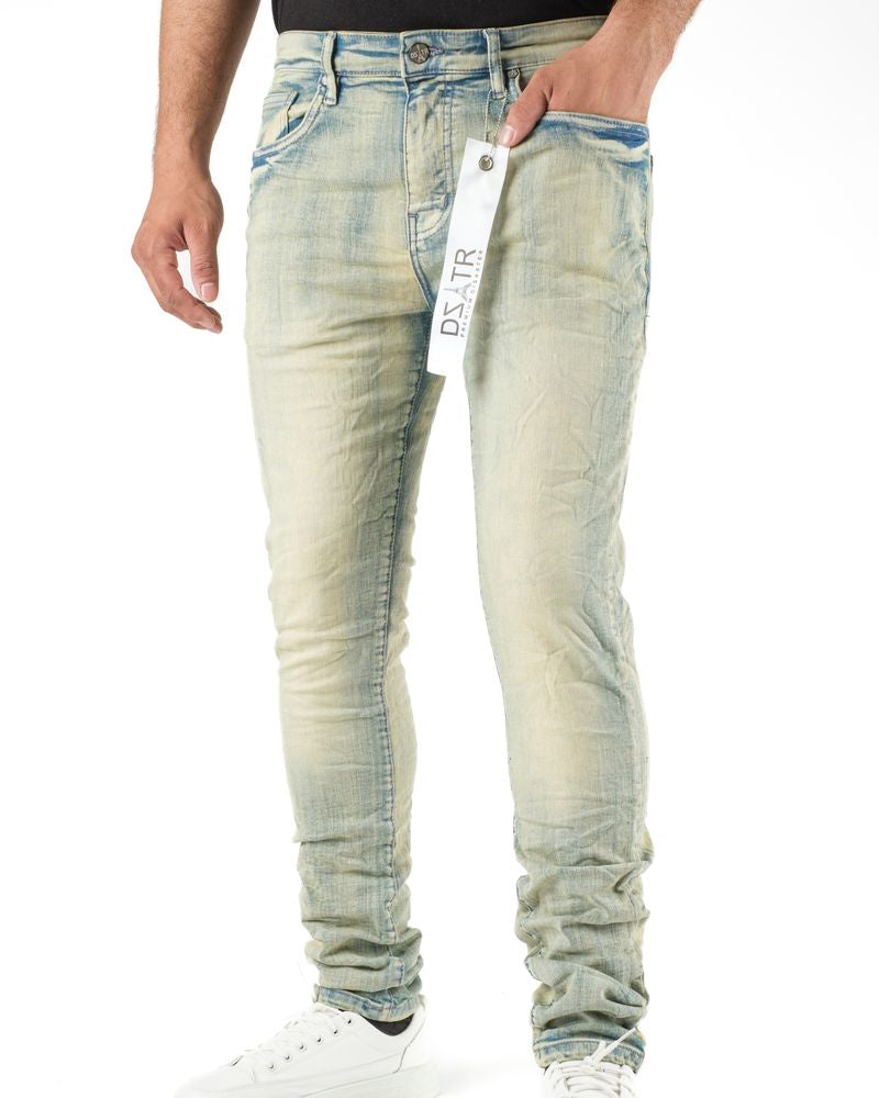 Person wearing light blue distressed jeans with a visible brand tag on a white background