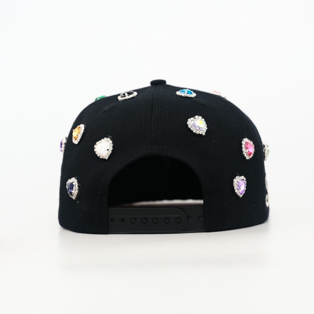 Black cap with colorful gemstones on a white background