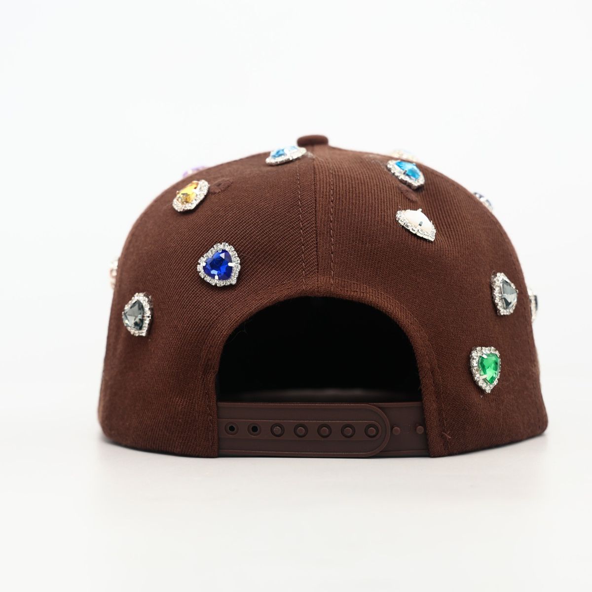 Brown cap with colorful gemstones on a white background