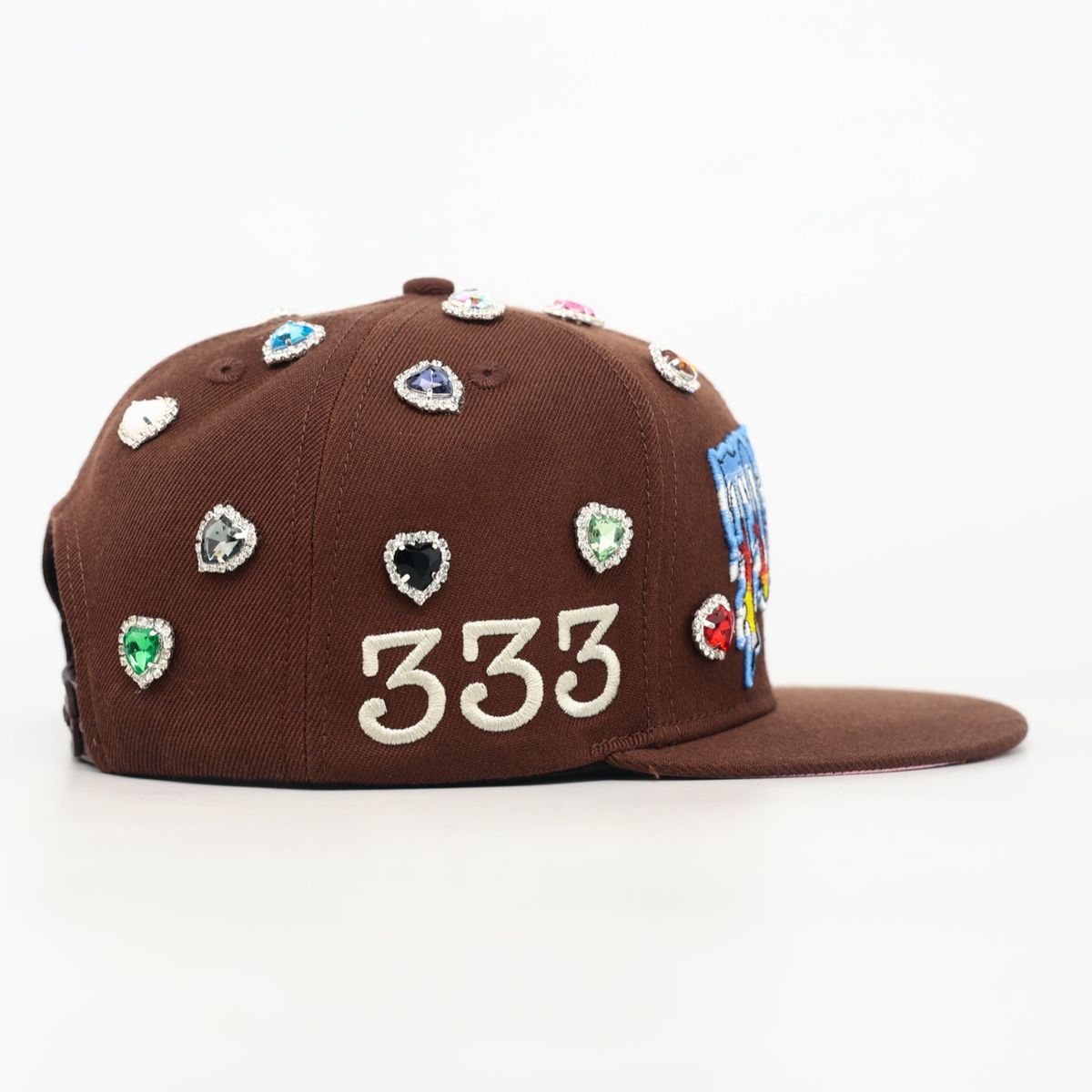 Brown cap with colorful gemstones and '333' on a white background
