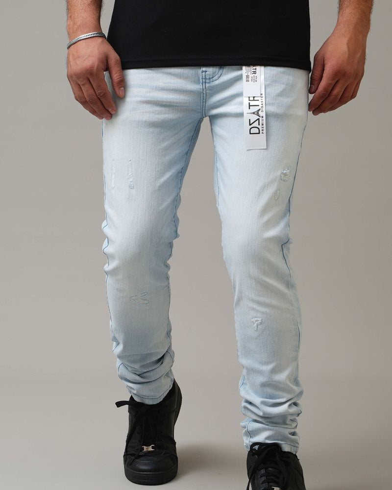 Person wearing light blue jeans with a brand label on a gray background