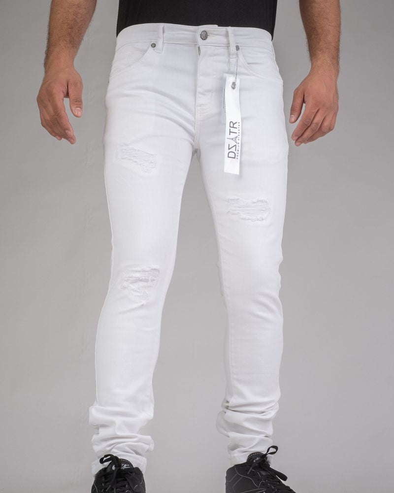 Person wearing white jeans with a brand tag on a gray background