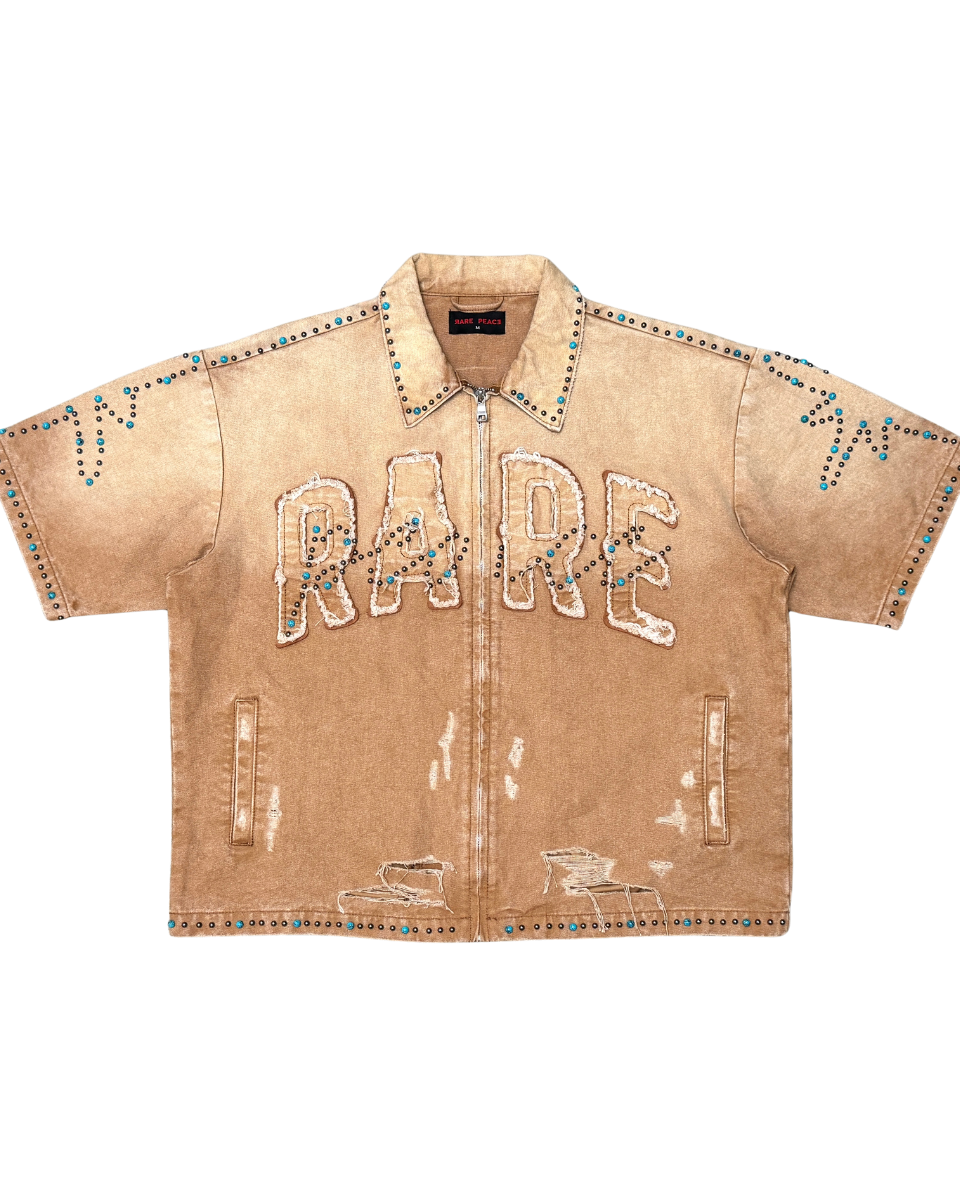 Beige denim shirt with 'RADE' embroidery on a white background