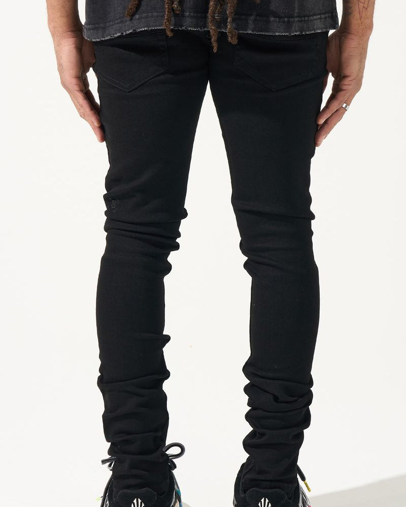 Person wearing black jeans and sneakers on a white background