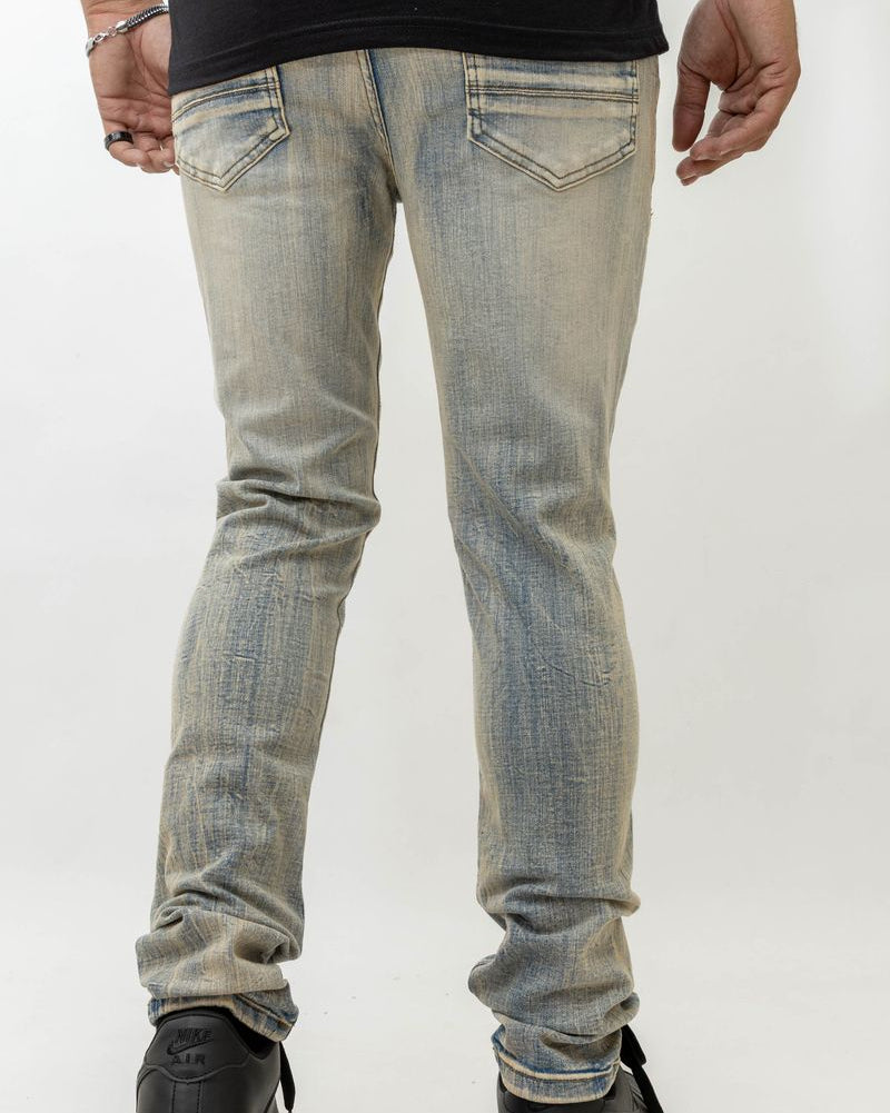 Person wearing light blue jeans and black shoes on a white background