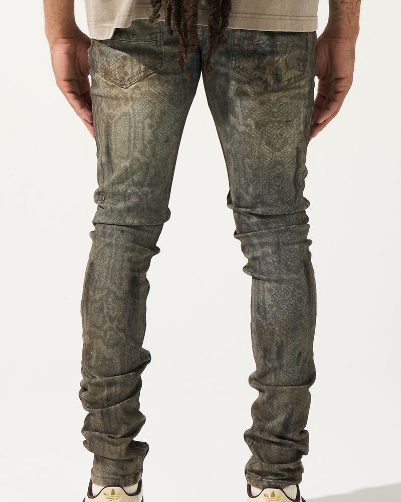 Person wearing distressed gray jeans and white sneakers on a plain background