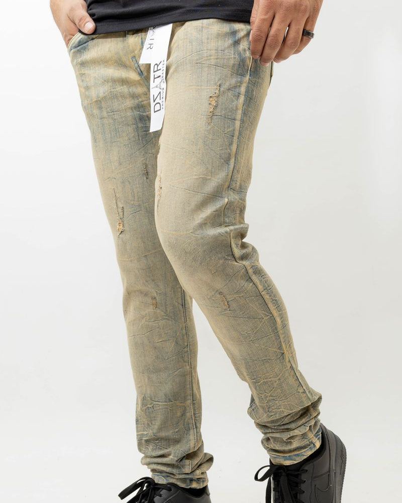 Person wearing light-colored distressed jeans and black shoes on a white background