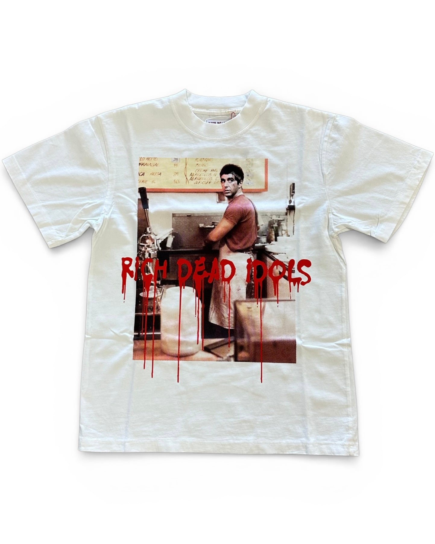 White t-shirt with a graphic design of a person in a room and 'Rich Dead Idols' text.