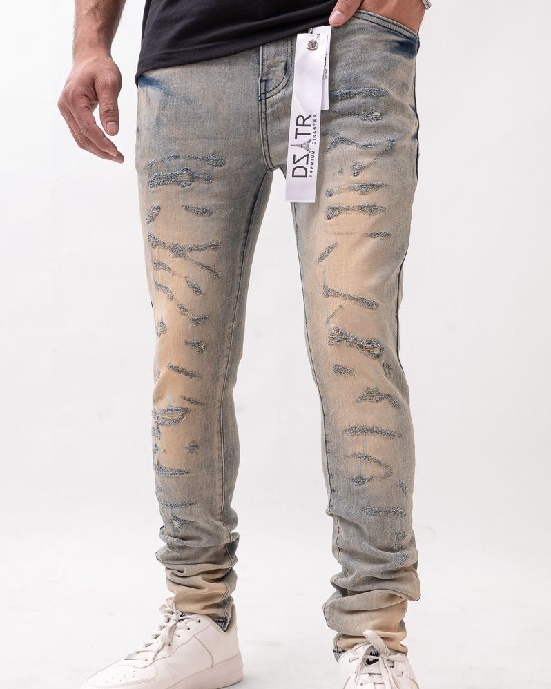 Person wearing distressed light blue jeans with a white background