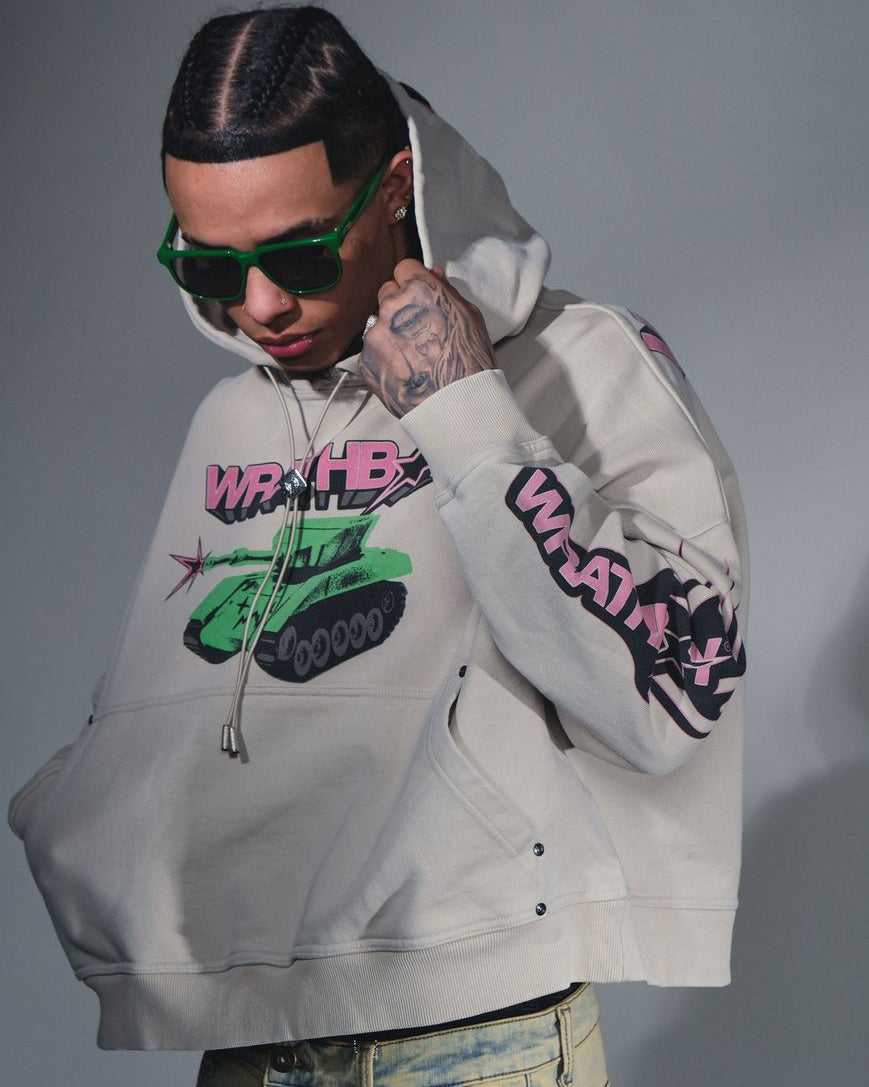 Person wearing a hoodie with colorful graphics and text, posing against a gray background