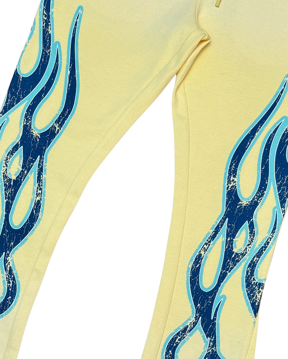 Yellow sweatpants with blue flame designs on a white background.