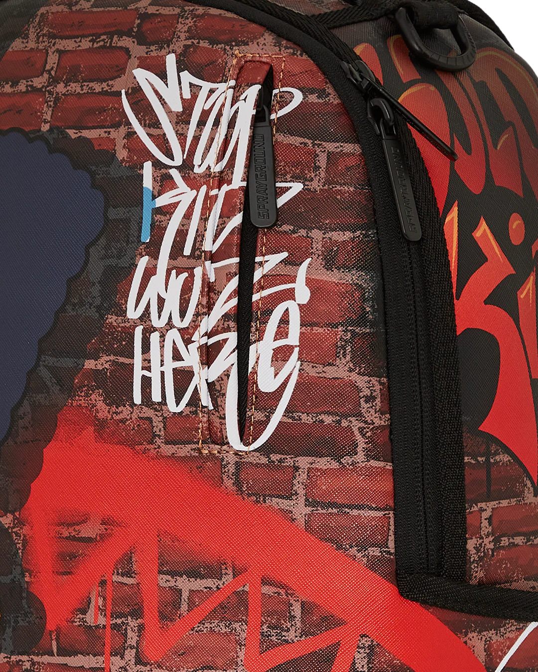 Backpack with graffiti-style text and red abstract design on a brick wall background
