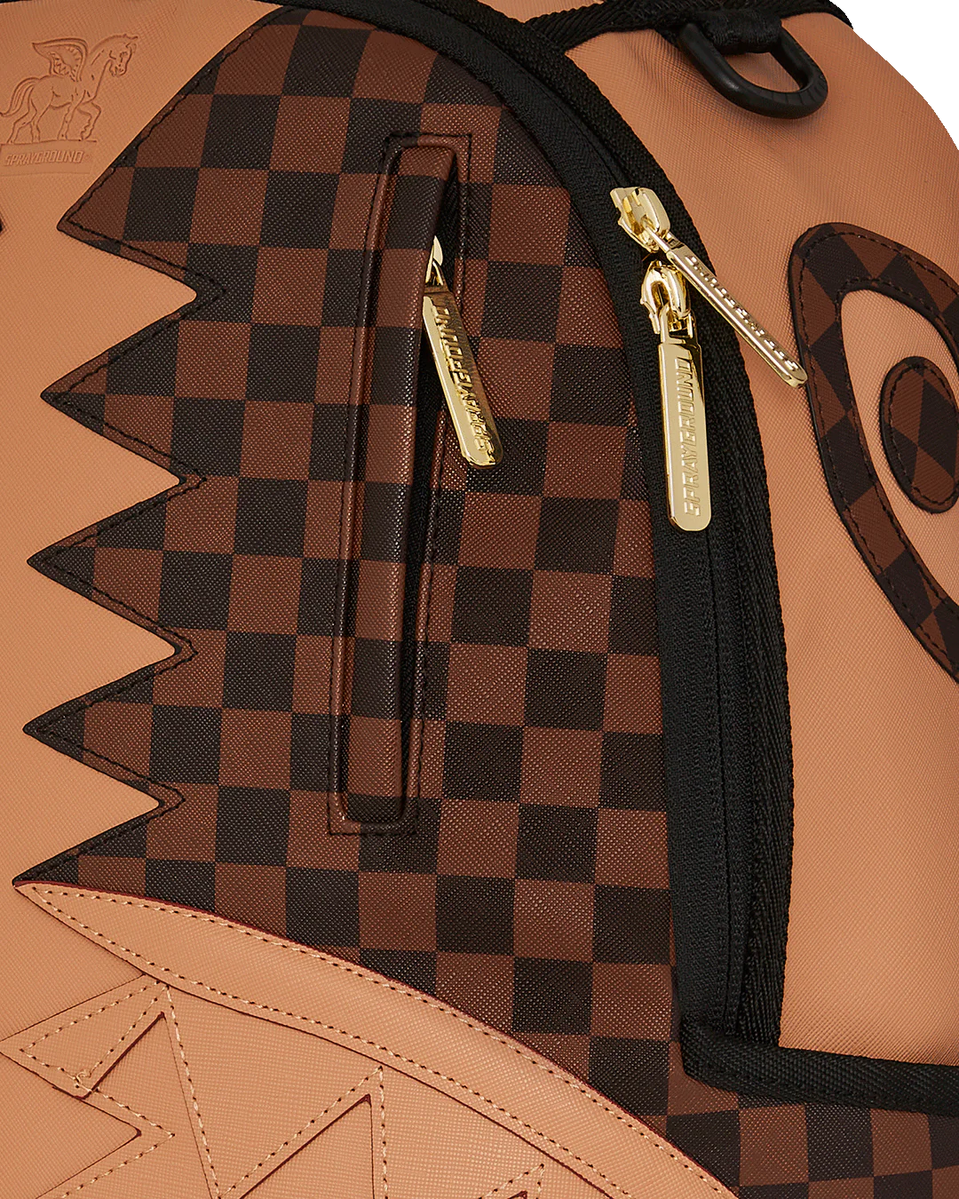 Close-up of a checkered backpack with gold zippers and star design.