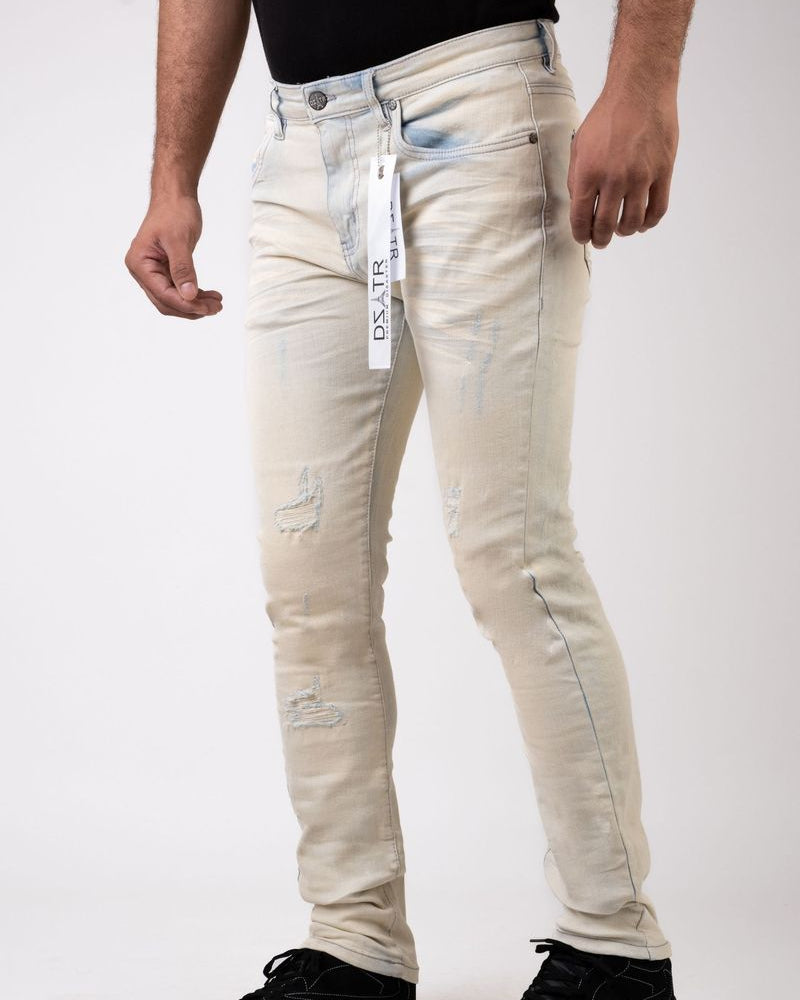 Person wearing light-colored distressed jeans with a visible brand label on a white background