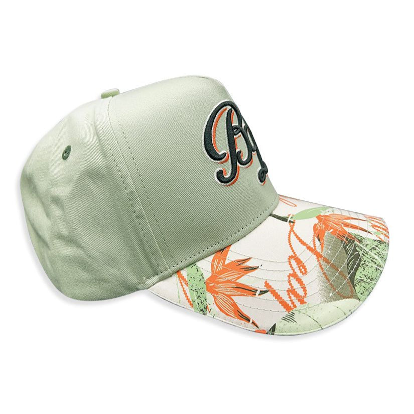 a sage green dad hat with a floral brim. The brand Blac Leaf embroidered the initials on the front face in complimenting thread.