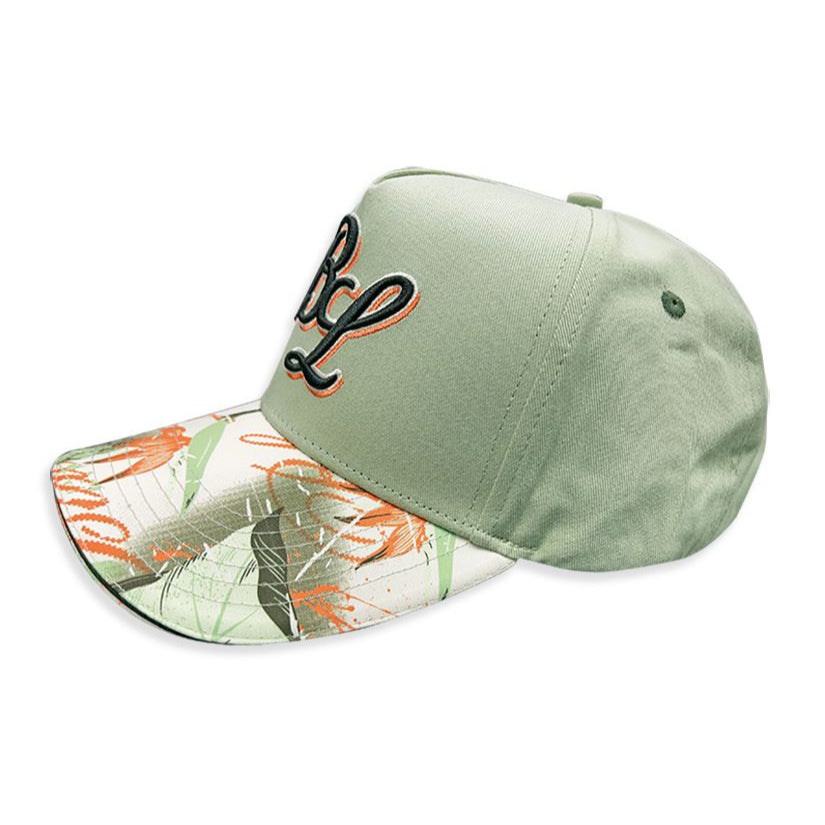 a sage green dad hat with a floral brim. The brand Blac Leaf embroidered the initials on the front face in complimenting thread.