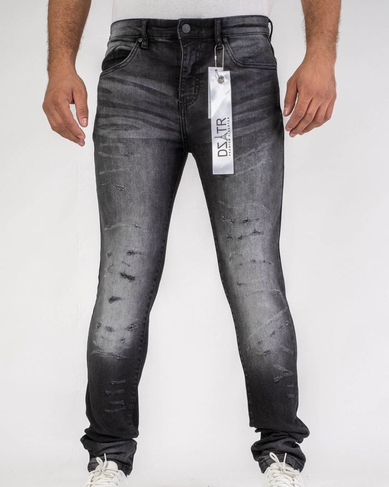 Black distressed jeans with a visible brand tag on a white background