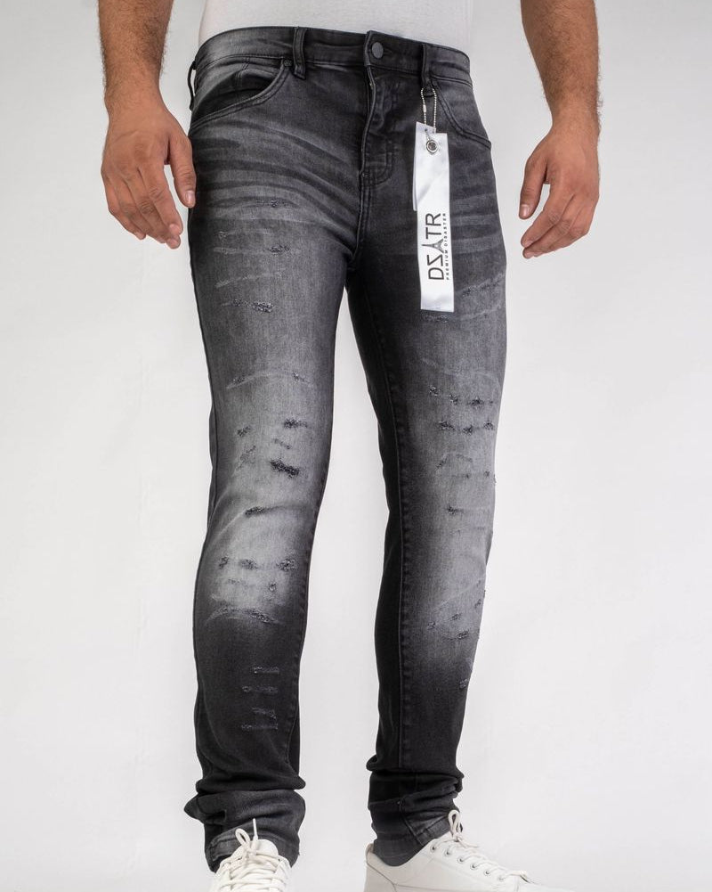 Person wearing black distressed jeans with a visible brand tag on a white background