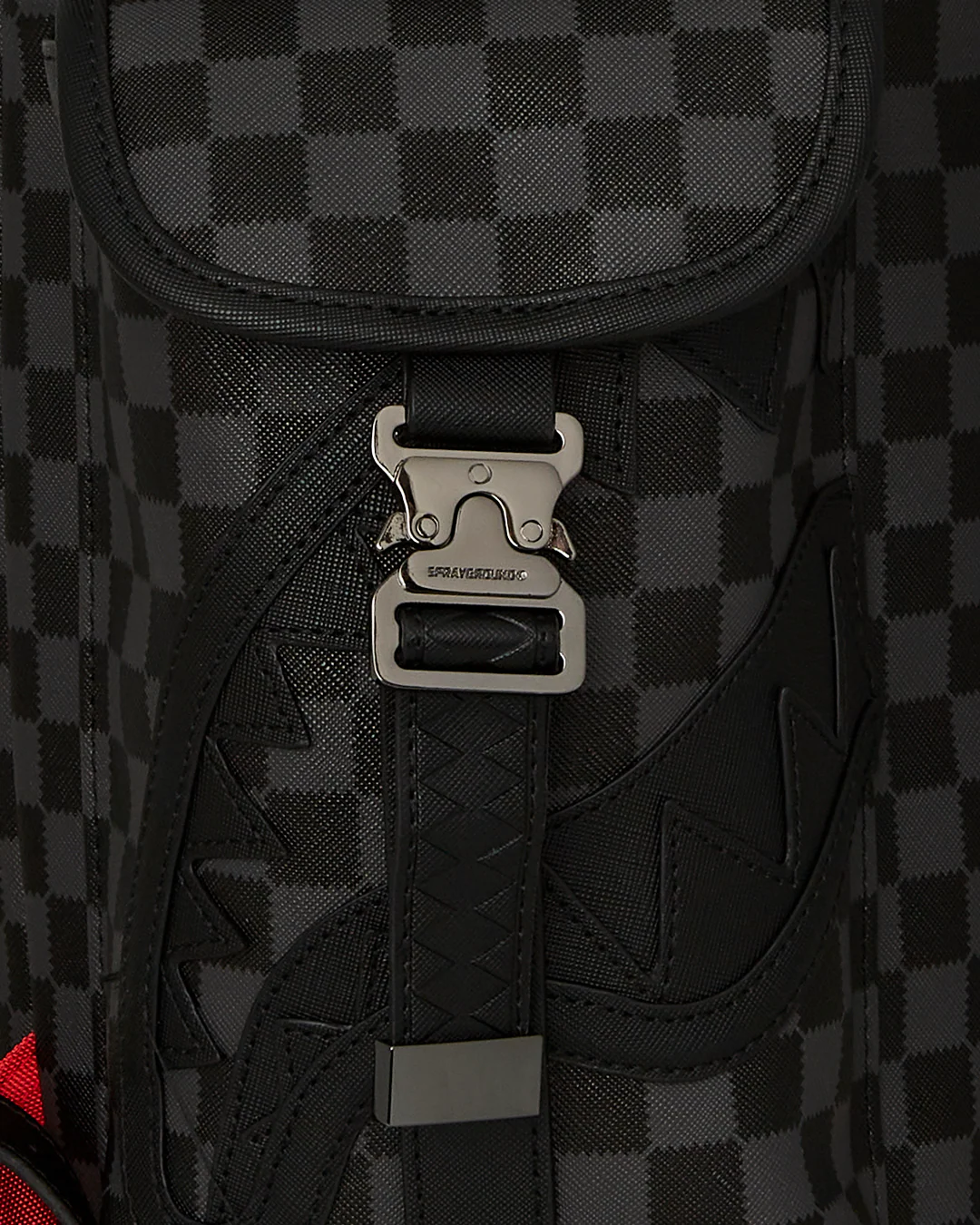 Close-up of a black and gray checkered bag with a silver buckle.