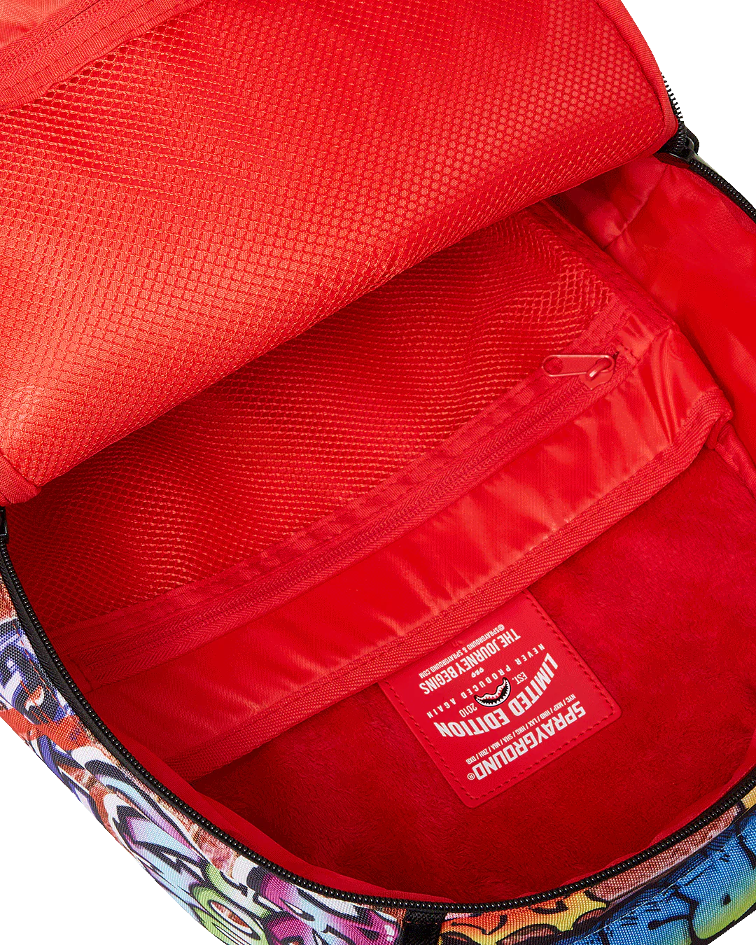 Red interior of a bag with a colorful exterior and a visible brand logo.