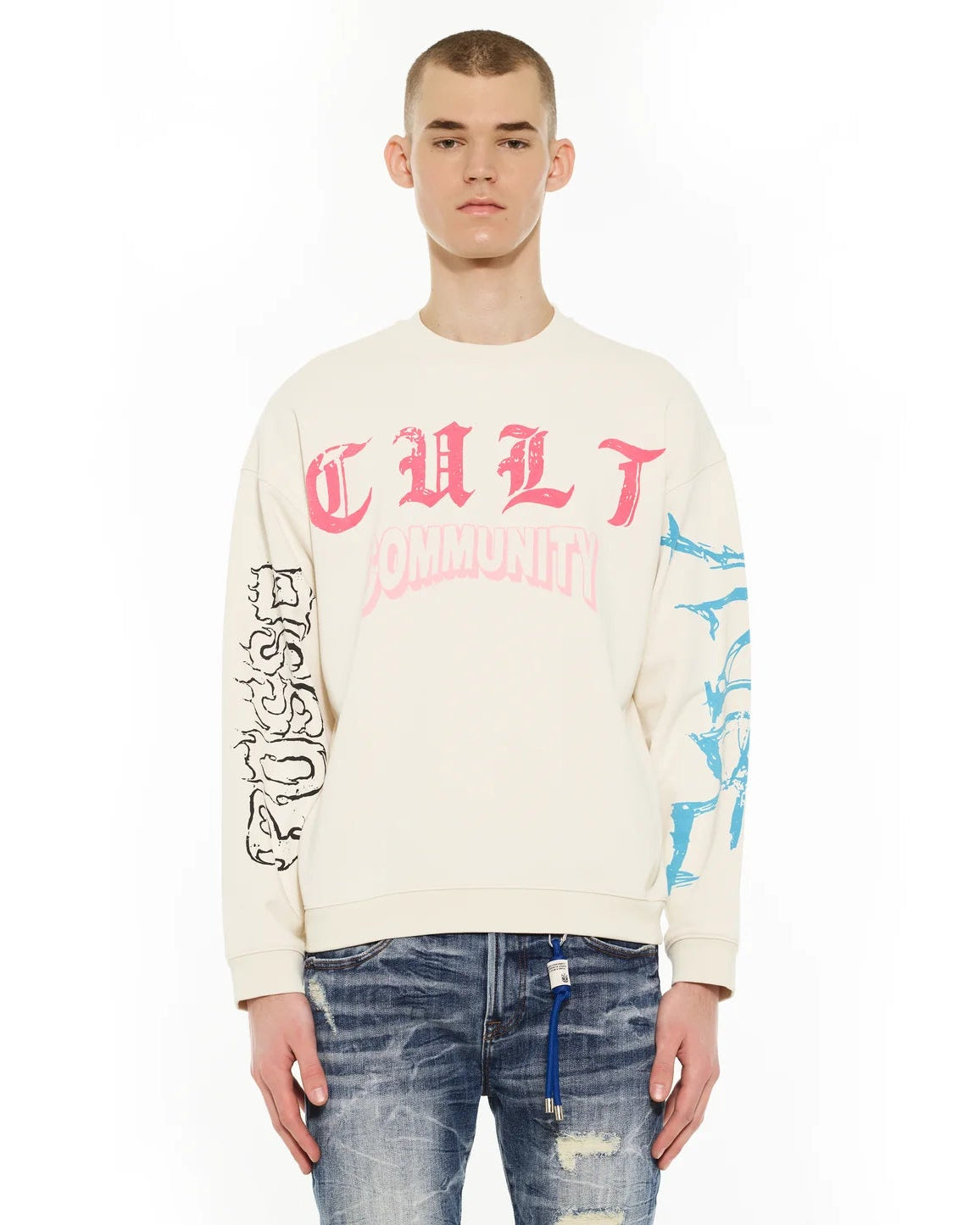 Person wearing a cream sweatshirt with pink text and graphics on a white background