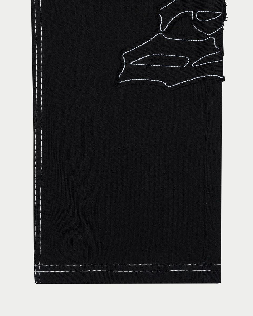 Black pants with white stitching on a light gray background