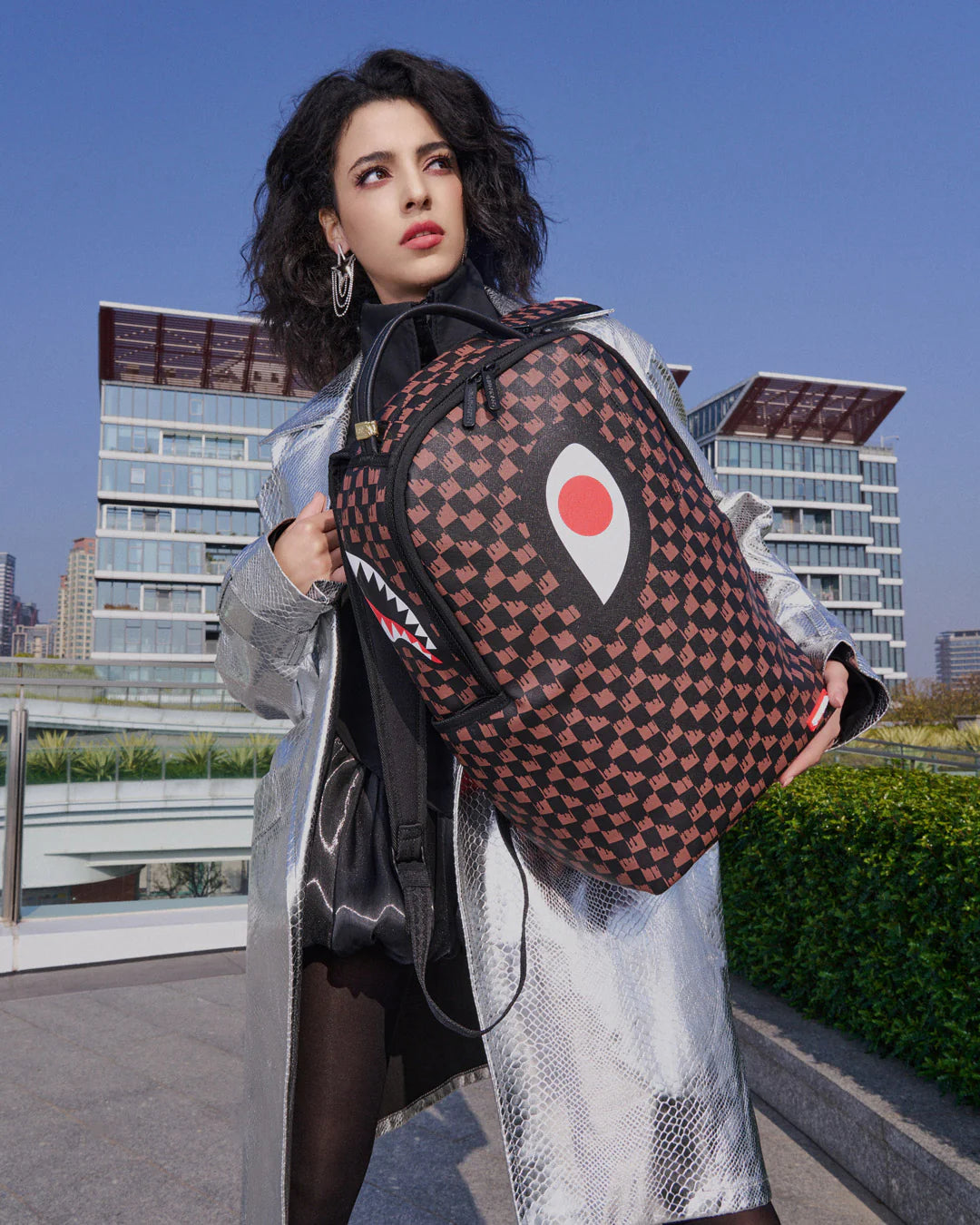 Woman holding a patterned bag with a cityscape in the background